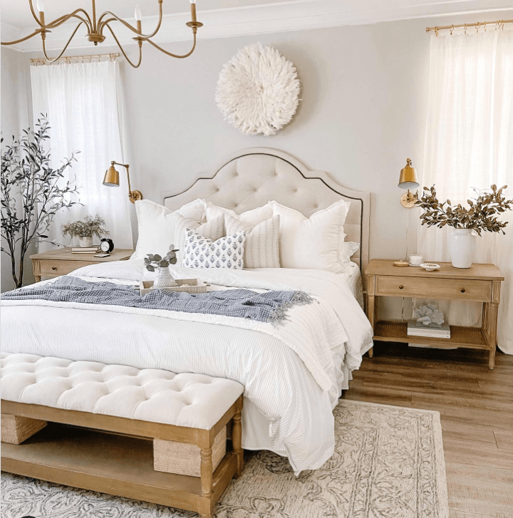 white bed with two nightstands and a bench